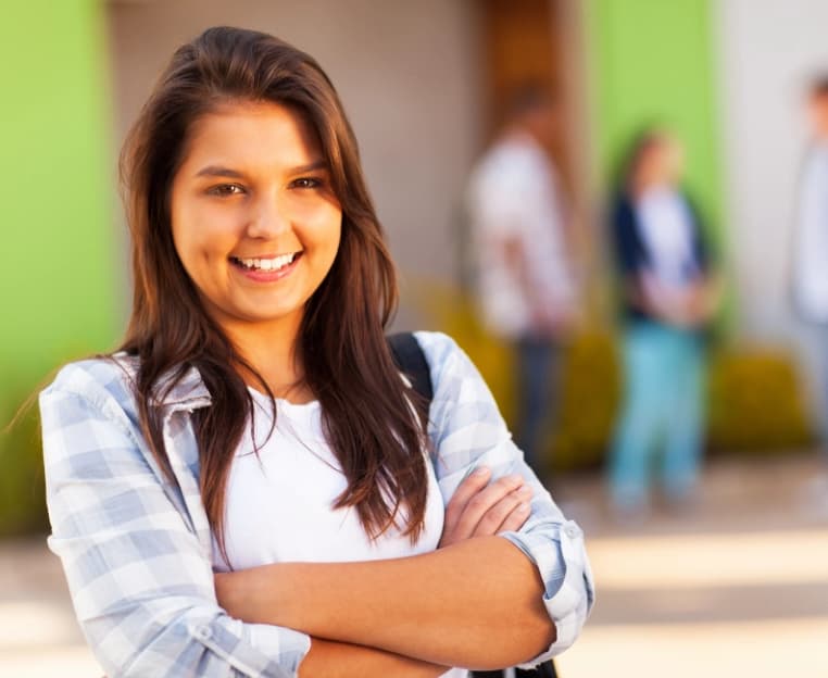 female student smiling with arms crossed